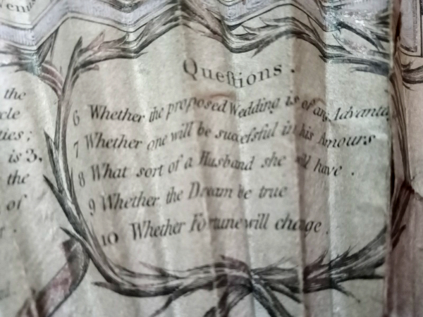 Close-up of a fan showing questions printed on