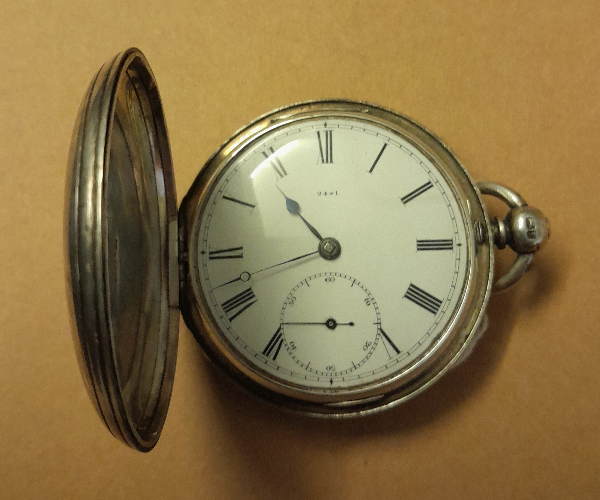 Pocket watch, with metal lid open to show the white face, roman numerals and hands showing the time
