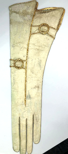 a long white glove with gold piping and buckles